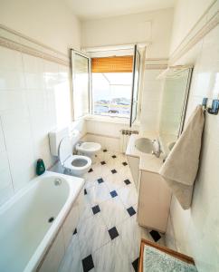 een badkamer met 2 toiletten, een bad en een wastafel bij Sunset Rooftop in Genua