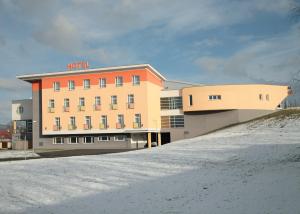 een hotelgebouw met sneeuw ervoor bij SPORTARÉNA TEPLICE příspěvková organizace in Teplice