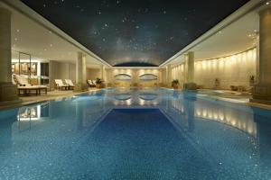 une grande piscine dans un hôtel doté d'un plafond étoilé dans l'établissement The Langham Sydney, à Sydney