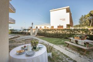 a table with plates of food and a bench at Casa Bartoli in San Vincenzo