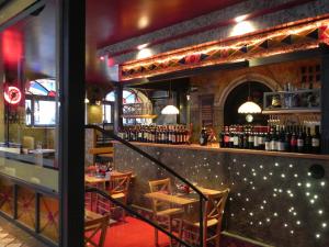 a restaurant with a bar with tables and wine bottles at Gente di Notte in Frascati