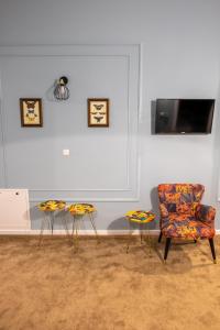 a living room with a chair and two stools at City Life Timisoara in Timişoara