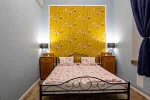 a bedroom with a bed with a yellow wall at City Life Timisoara in Timişoara