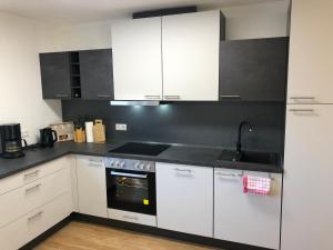 a kitchen with white cabinets and a stove top oven at Ferienhaus Eisenach in Eisenach +7 photos