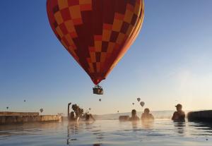 een groep mensen in het water met een heteluchtballon bij Museum Hotel in Uchisar