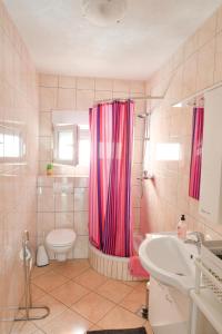 baño con cortina de ducha rosa y aseo en Apartments Boženka, en Klek