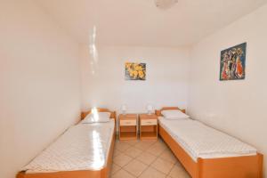 Habitación con 2 camas y mesa. en Apartments Boženka, en Klek