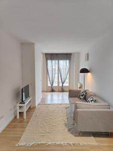 a living room with a couch and a tv at Cute apartment Sant Adria beach in Sant Adria de Besos