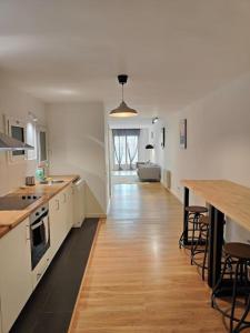 una gran cocina blanca con un largo suelo de madera en Cute apartment Sant Adria beach, en Sant Adrià de Besòs