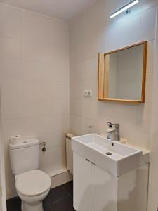 a white bathroom with a toilet and a sink at Cute apartment Sant Adria beach in Sant Adria de Besos +9 photos