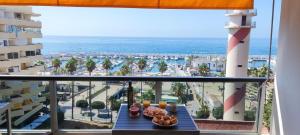 a table with food on a balcony with a view of the beach at Apto Puerto Deportivo el Faro Marbella in Marbella