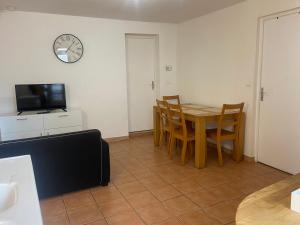 comedor con mesa, sillas y reloj en L'appartement ZEN LOC 2, en Bray-sur-Seine