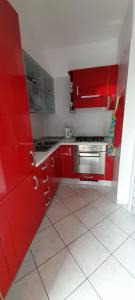 cocina roja con armarios rojos y fogones en I meridiani, en Montesilvano