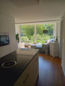 a kitchen with a large window and a living room at Neue Wohnung an Stadtrand mit Parkplatz in Luzern