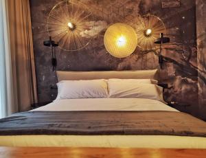 a bedroom with a large bed and two lights at Les Cases del Mar in Les Cases d'Alcanar