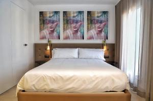 レス・カセス・ダルカナールにあるLes Cases del Marのベッドルーム1室(ベッド1台付)が備わります。壁には絵画が飾られています。
