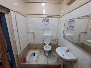 a bathroom with a toilet and a sink at Jagan Hotel & Restaurant in Dhaulpur +17 photos