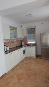 a kitchen with white cabinets and stainless steel appliances at David Apartman in Gyula