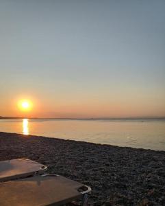 a table and chairs on a beach at sunset at Villa Beta - 5min walk to beach, BBQ, Parking in Pefkohori