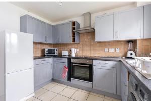 a kitchen with stainless steel appliances and white cabinets at Beautiful Comfortable Double Room in Thamesmead