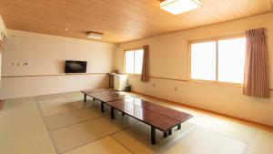 a large room with a table and a tv at Resort Inn Fuyo Kawaguchiko Inter in Fujiyoshida
