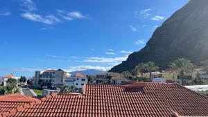 vistas a una ciudad con techos rojos y una montaña en Sea and Sun 4 You - Porto Moniz, en Porto Moniz