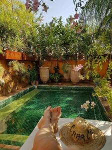 une personne se posant au bord d'une piscine dans l'établissement Riad Laith, à Marrakech