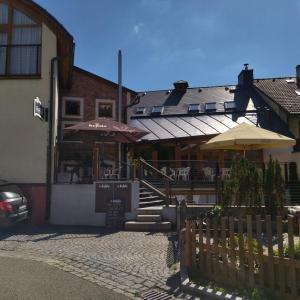 ein Gebäude mit einem Restaurant mit Tischen und Sonnenschirmen in der Unterkunft Apartmány s výhledem na zámek II in Vimperk