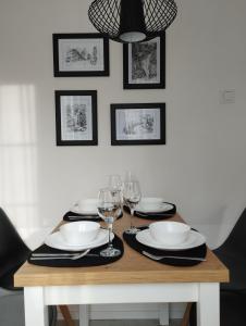 a dining room table with plates and wine glasses at Apartament pod Świerkami in Szklarska Poręba