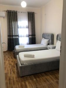 a room with two beds and a couch and a window at Drini Apartments in Përmet