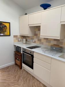 a kitchen with white cabinets and a stove top oven at The Gallery, Warwick in Warwick