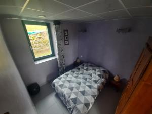 a small bedroom with a bed and a window at Gîte Le Chant des Cloches in Fleurey