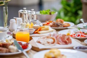 a table topped with plates of food and drinks at Hotel am Schlosspark Superior - Adults Only Hotel in Putbus