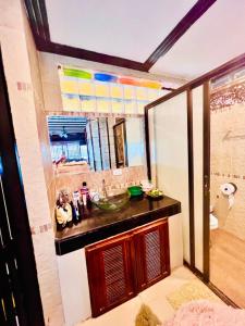 Crystal Sea Villa في كو لان: حمام مع حوض ومرآة