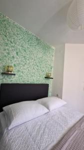 uma cama num quarto com uma parede verde em Studio Nina em Kaštel Štafilić