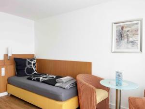 a small bedroom with a bed and a table at Schöne Apartments I private Parkplätze I home2share in Münster