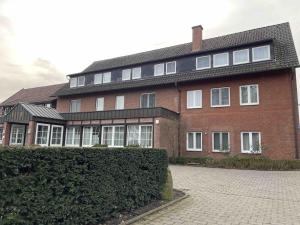 a large brick house with a hedge in front of it at Schöne Apartments I private Parkplätze I home2share in Münster