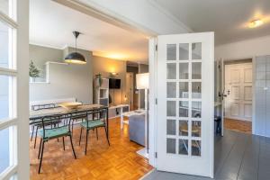 uma cozinha e sala de estar com mesa e cadeiras em RenFeb23Boavista Deluxe with private parking no Porto