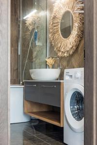 a bathroom with a sink and a washing machine at Pajūrio Oazė MG13 in Klaipėda