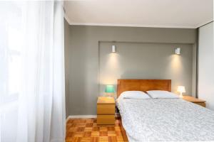 um quarto com uma cama grande e uma janela em RenFeb23Boavista Deluxe with private parking no Porto