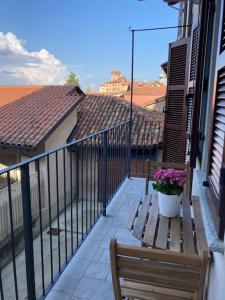 un balcón con un banco y flores en un edificio en Casa Patrito - Appartamento Dolcetto, en Barolo