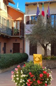 un edificio con banderas y flores en un patio en Casa Patrito - Appartamento Dolcetto, en Barolo