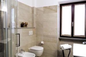een badkamer met een toilet, een wastafel en een raam bij Casa Patrito - Appartamento Dolcetto in Barolo