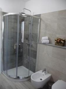 y baño con ducha, aseo y lavamanos. en Casa Patrito - Appartamento Dolcetto, en Barolo