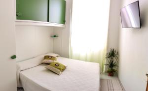 a bedroom with a white bed with two pillows on it at Villa catalana al centro di Alghero in Alghero