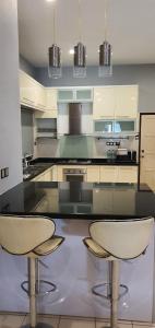 una cucina con due sedie e un piano di lavoro di Luxury & Complete 3 Bedroom Penthouse a Shah Alam