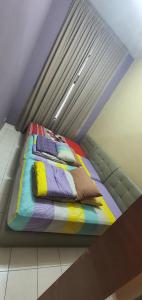 un letto con coperte e cuscini colorati in una stanza di Luxury & Complete 3 Bedroom Penthouse a Shah Alam