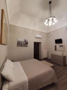una camera con un grande letto e una televisione di Lo Stemma B&B Guest House a Melfi