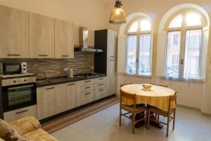 a kitchen with a table and a dining room at Villa catalana al centro di Alghero in Alghero