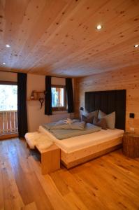 - une chambre avec un grand lit dans une cabane en rondins dans l'établissement Lüch dl Finatzer, à San Martino in Badia